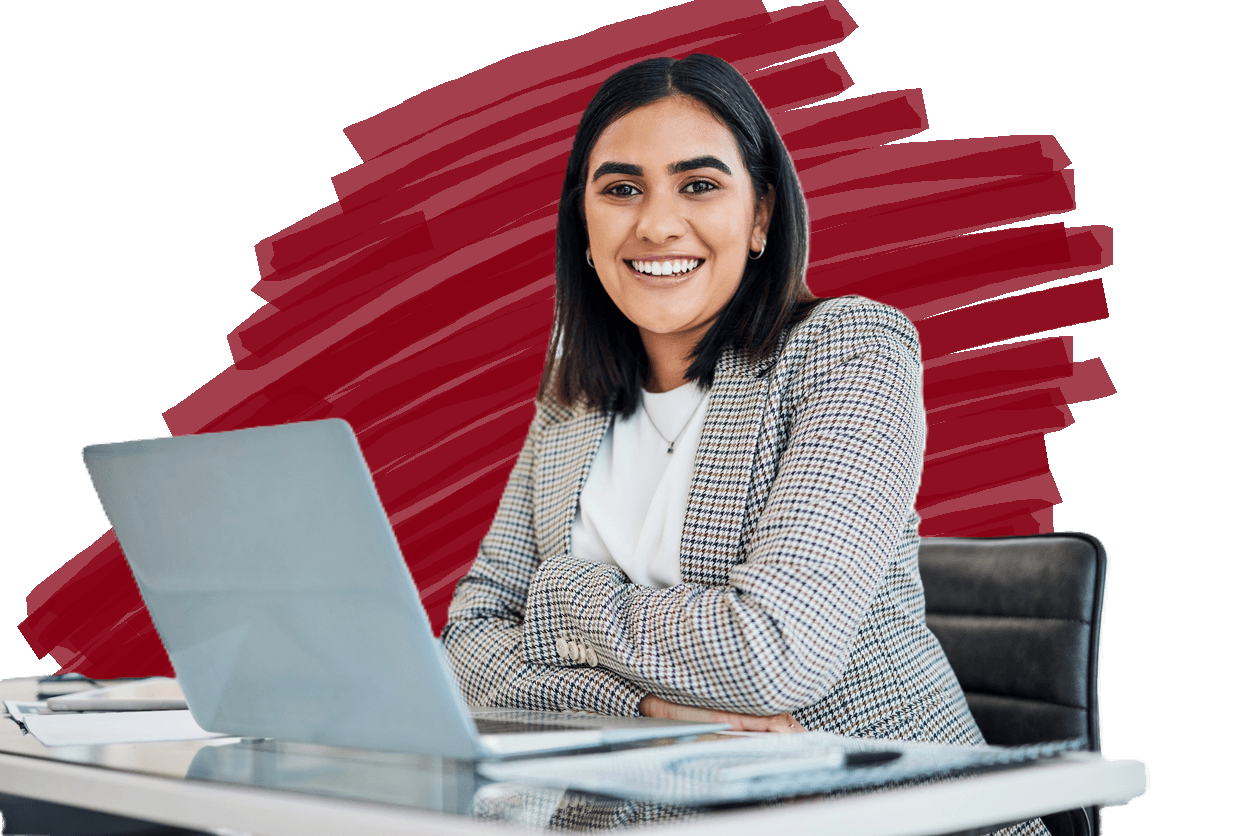 A smiling, confident female employee with a computer in front of her.